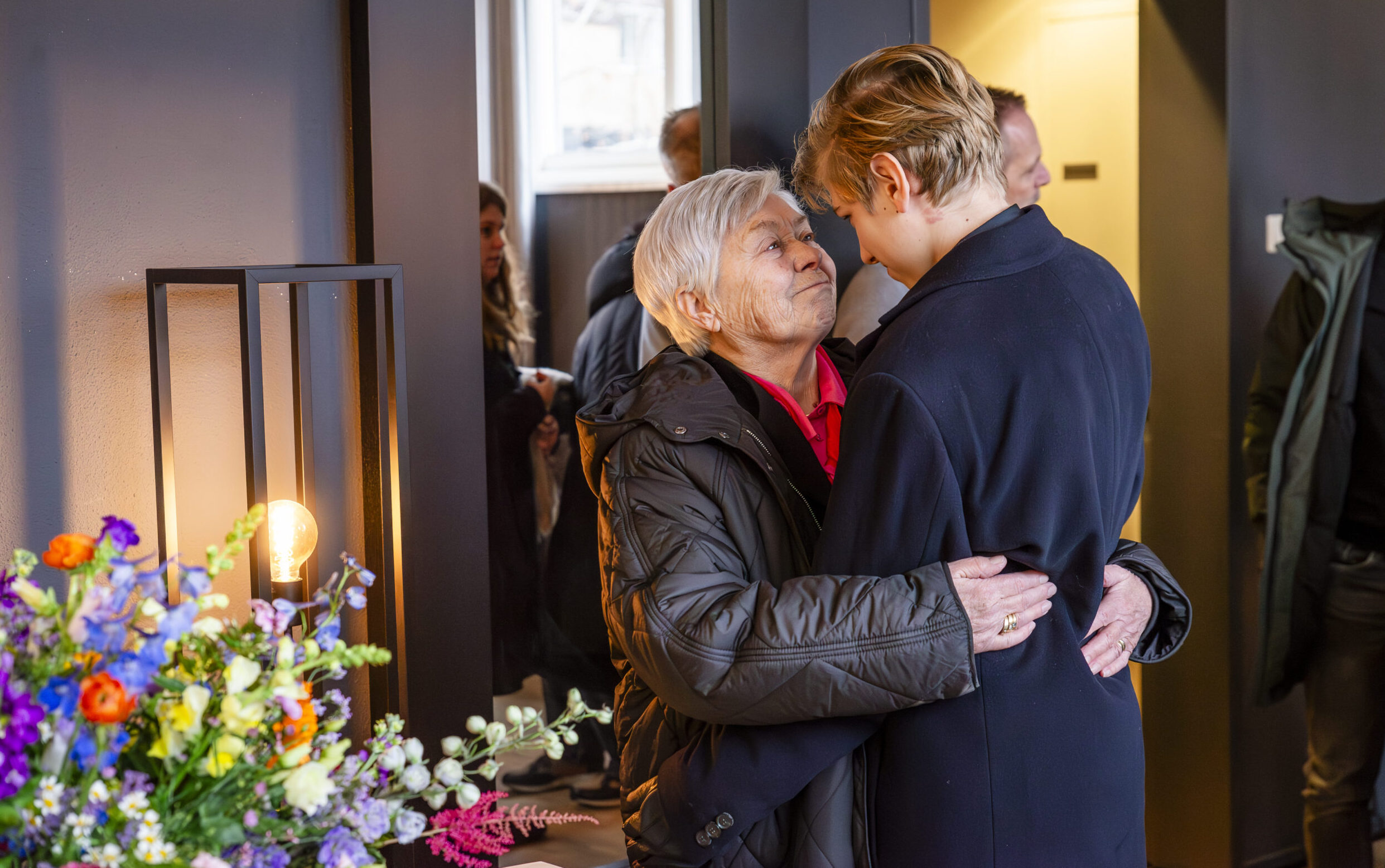 Twee mensen omhelzen elkaar tijdens een persoonlijk afscheid, een moment van troost en verbondenheid bij Huiting Uitvaartverzorging.
